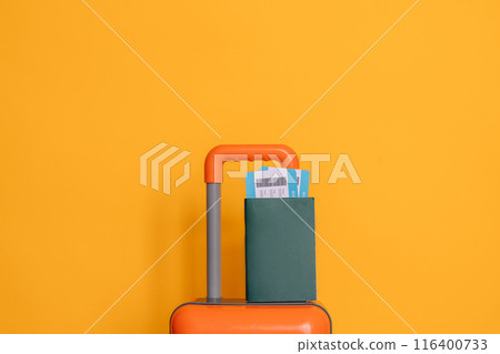 International passport with tickets on an orange suitcase against a yellow background International passport with tickets on an orange suitcase against a yellow background 116400733