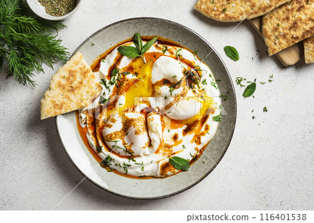 Turkish eggs Cilbir and fresh pita bread Turkish eggs Cilbir and fresh pita bread 116401538