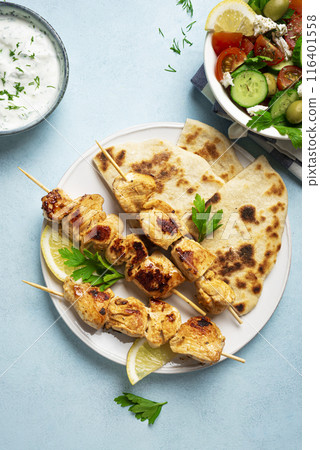 Chicken souvlaki kebabs and greek salad Chicken souvlaki kebabs and greek salad 116401558