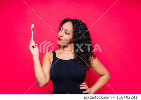 Pretty african lady with beautiful smile holding toothbrush and taking care of her teeth health Pretty african lady with beautiful smile holding toothbrush and taking care of her teeth health 116402241