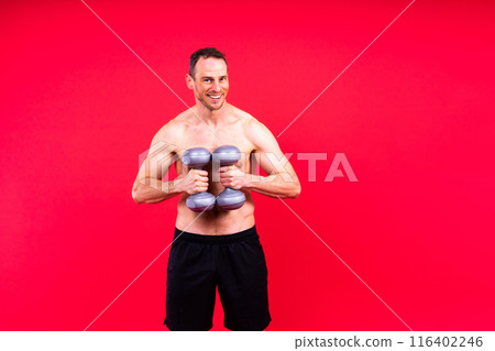 Bodybuilder exercising with dumbbells. Topless young man working out on studio background. Bodybuilder exercising with dumbbells. Topless young man working out on studio background. 116402246