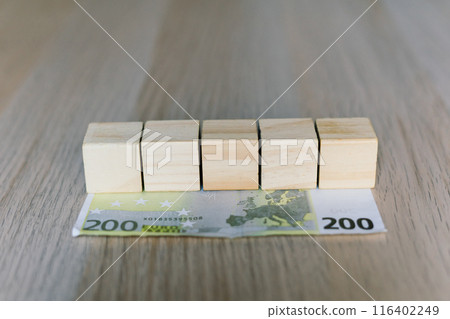 Wooden cubes blocks, money 200 Euro banknotes. Management big salary career concept. 116402249