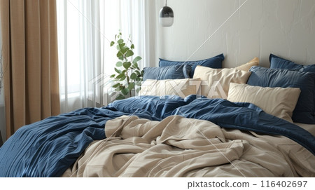 Bed with blue and beige bedding. Boho, farmhouse interior design of modern bedroom. 116402697