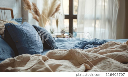 Bed with blue and beige bedding. Boho, farmhouse interior design of modern bedroom. 116402707