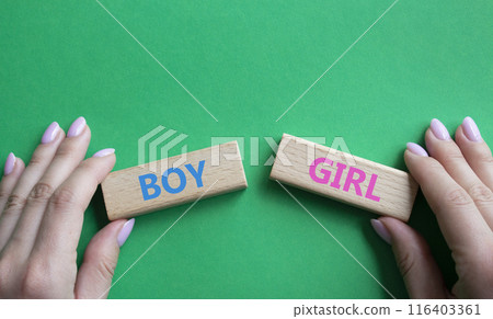 Boy or Girl symbol. Concept word Boy or Girl on wooden blocks. Man hand. Beautiful green background. Gender and Boy or Girl concept. Copy space Boy or Girl symbol. Concept word Boy or Girl on wooden blocks. Man hand. Beautiful green background. Gender and Boy or Girl concept. Copy space 116403361