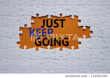 Just keep going symbol. White puzzle with words Just keep going. Beautiful orange background. Business and Just keep going concept. Copy space. 116403388