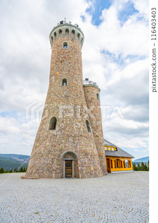 A stone lookout tower with a wooden door, surrounded by cobblestones. The tower is located in Czechia and is a popular tourist destination. A stone lookout tower with a wooden door, surrounded by cobblestones. The tower is located in Czechia and is a popular tourist destination. 116403403