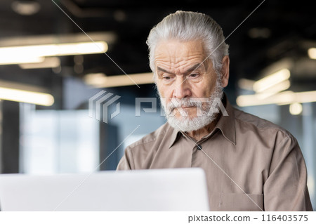 Elderly man with grey hair and beard concentrating on laptop screen in contemporary office. Concept of senior, technology, business, focus, modern workspace. Elderly man with grey hair and beard concentrating on laptop screen in contemporary office. Concept of senior, technology, business, focus, modern workspace. 116403575