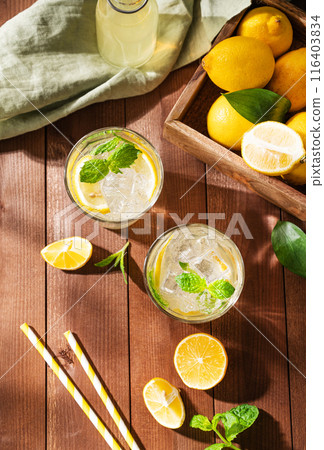 Two glasses of Lemonade drink with fresh lemons. Refreshing cocktails with lemon, mint and ice  116403834