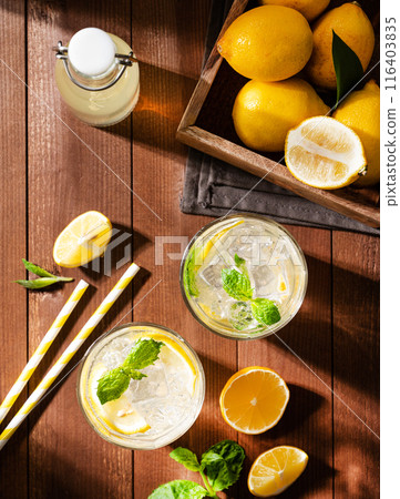 Two glasses of Lemonade drink with fresh lemons. Refreshing cocktails with lemon, mint and ice  116403835