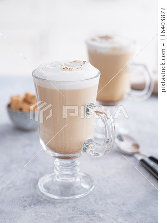Two glasses of fragrant cappuccino coffee with cinnamon on a blue table  116403872