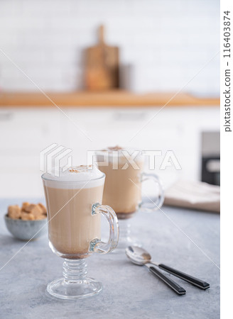 Two glasses of fragrant cappuccino coffee with cinnamon on a blue table  116403874
