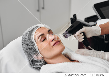 A woman receives Rf-lifting in a beauty salon. A woman receives Rf-lifting in a beauty salon. 116403979