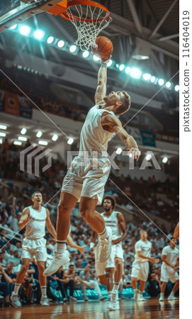 basketball player soaring through the air, aggressively dunking the ball during an intense game, capturing a moment of power and athleticism. 116404019