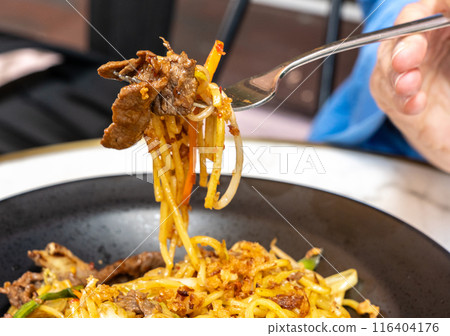 Udon Street Food on Fork Closeup, Chinese Fried Noodles, Beef Spaghetti with Vegetables in Hand Udon Street Food on Fork Closeup, Chinese Fried Noodles, Beef Spaghetti with Vegetables in Hand 116404176