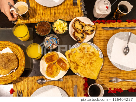 Moroccan breakfast ftour, msemen, baghrir, orange juice, pastries, bread basket, fried eggs, cheese cubes 116404257