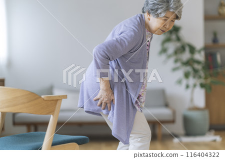 Elderly woman holding her waist, lower back pain, back pain image 116404322