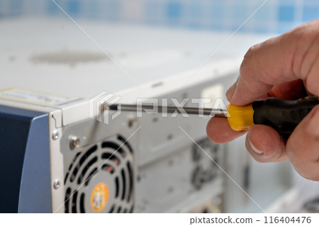technician adjusting the screw on a cabinet lid. 116404476