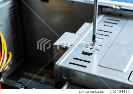 technician adjusting the screw on a cabinet lid. 116404483