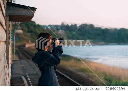 A woman holding a camera on the station platform A woman holding a camera on the station platform 116404694