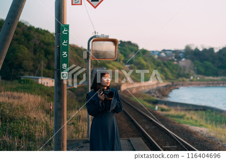 A woman holding a camera on the station platform A woman holding a camera on the station platform 116404696