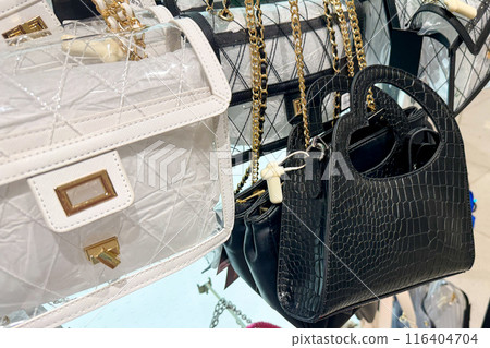 stylish handbags featuring various designs, including a white quilted bag and a black croc-embossed bag, with gold chain straps 116404704