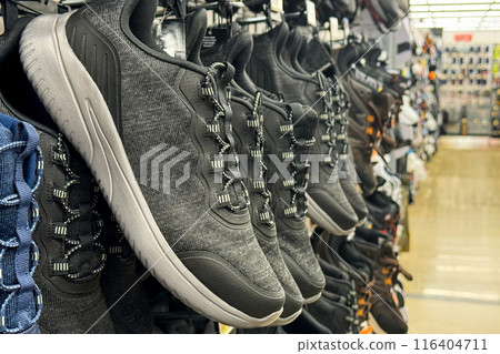 a row of gray athletic shoes on display in a store a row of gray athletic shoes on display in a store 116404711