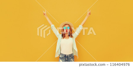 Fashionable happy cheerful young woman raising her hands up, stylish girl model having fun on yellow 116404976