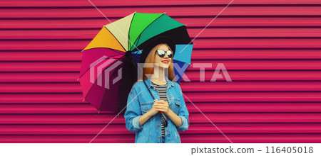 Portrait stylish happy smiling young woman holding colorful umbrella in glasses on pink background Portrait stylish happy smiling young woman holding colorful umbrella in glasses on pink background 116405018