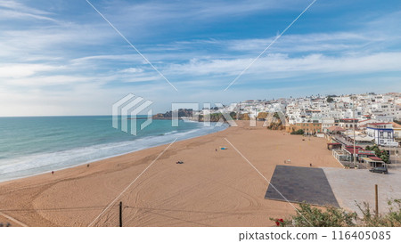 Wide sandy beach and Atlantic ocean in city of Albufeira timelapse. Algarve, Portugal 116405085