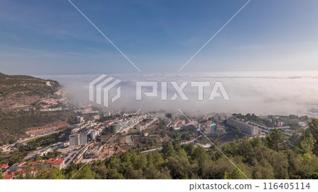 Panorama showing aerial View of Sesimbra Town and Port covered by fog timelapse, Portugal. 116405114