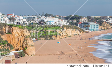 Wide sandy beach and Atlantic ocean in city of Albufeira timelapse. Algarve, Portugal 116405161