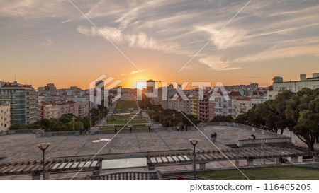 Panorama showing sunset over lawn at Alameda Dom Afonso Henriques and the Luminous Fountain aerial timelapse in Lisbon. 116405205