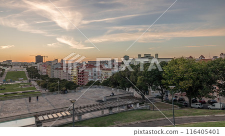 Panorama showing sunset over lawn at Alameda Dom Afonso Henriques and the Luminous Fountain aerial timelapse in Lisbon. 116405401