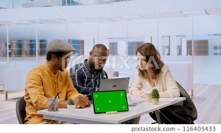 Clients negotiating with realtor next to isolated copy space on tablet, examining layout and blueprints for new high class office space. Business people investing in property with financier. Camera A. Clients negotiating with realtor next to isolated copy space on tablet, examining layout and blueprints for new high class office space. Business people investing in property with financier. Camera A. 116405433