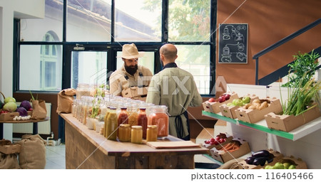 Local farmer delivers products to seller in zero waste eco supermarket, bringing freshly harvested fruits and vegetables in crates. Small business owner supplies vendor with natural goods. 116405466