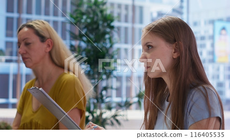 Young adult reading personalized financial plan given by financial advisor during meeting in office. Teenager reading how to make profitable and futureproof economic decisions, camera B 116405535