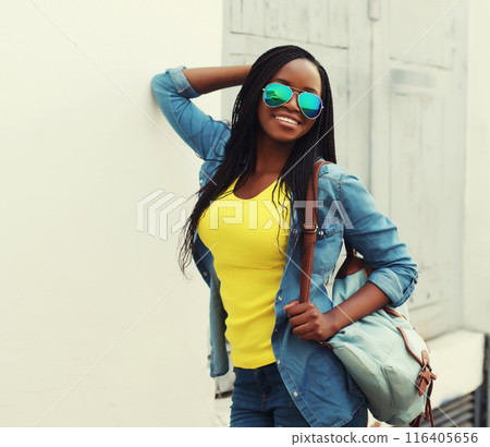 Portrait of happy stylish young african woman in casual clothing, glasses posing in the city 116405656