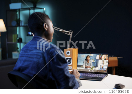 Black woman making video call with group of colleagues on a digital laptop. Attending conference meetings and webinars via portable computer as an African American female freelancer. 116405658
