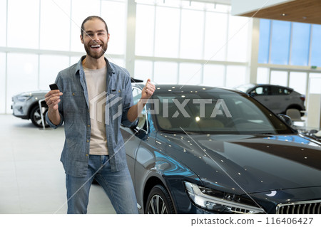 Confident young man in casual clothes near the car Confident young man in casual clothes near the car 116406427