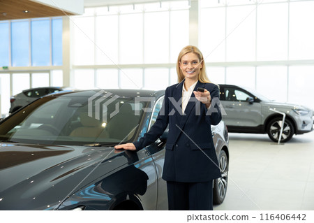 Blonde woman in elegant suit standing near the car with the key Blonde woman in elegant suit standing near the car with the key 116406442