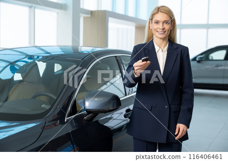 Elegant blonde woman holding a car key in hands Elegant blonde woman holding a car key in hands 116406461