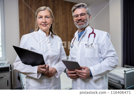Doctors in lab coats standing close and looking confident 116406471