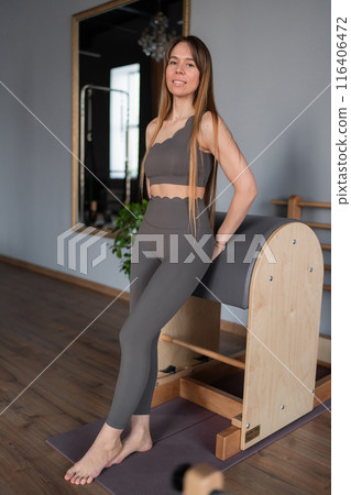 Pilates fitness trainer in pilates studio. Young sporty attractive woman wearing sportswear in yoga studio. Fit, healthy and strong authentical body. Fitness concept Pilates fitness trainer in pilates studio. Young sporty attractive woman wearing sportswear in yoga studio. Fit, healthy and strong authentical body. Fitness concept 116406472