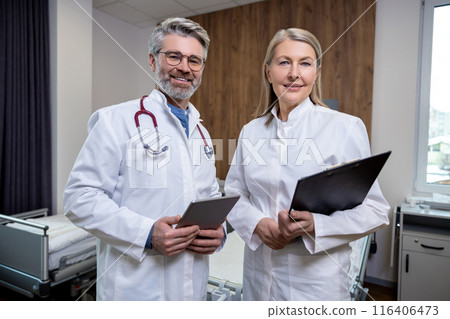 Doctors in lab coats standing close and looking confident Doctors in lab coats standing close and looking confident 116406473