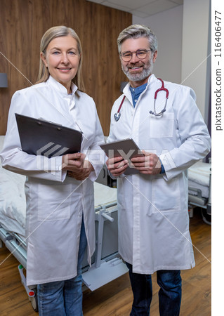 Doctors in lab coats standing close and looking confident Doctors in lab coats standing close and looking confident 116406477