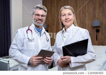 Doctors in lab coats standing close and looking confident Doctors in lab coats standing close and looking confident 116406485
