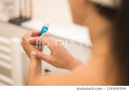 Woman applying anti-age serum on her skin Woman applying anti-age serum on her skin 116406504