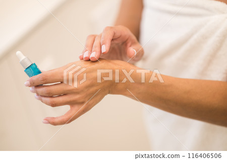 Woman applying anti-age serum on her skin Woman applying anti-age serum on her skin 116406506