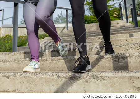 Unrecognizable women running on stairs during sunny morning on stadium 116406893